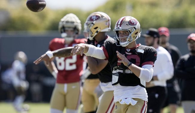 San Francisco 49ers quarterback Brock Purdy, right, throws a pass while taking part in a drill during NFL football training camp Friday, Aug. 4, 2023, in Santa Clara, Calif. (AP Photo/Godofredo A. Vásquez)