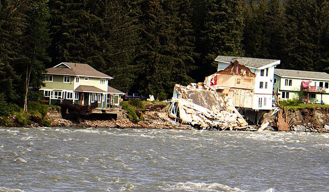 A home hangs over the edge of an eroded riverbank after part of the neighboring house fell into the Mendenhall River in Juneau, Alaska, on Sunday, Aug. 6, 2023. The city of Juneau says the Mendenhall River flooded on Saturday because of a major release from Suicide Basin above Alaska&#x27;s capital city, and at least two buildings were destroyed. (Mark Sabbatini/Juneau Empire via AP)