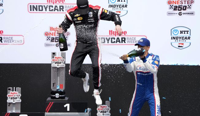 Josef Newgarden is sprayed with champagne by Alex Palou, of Spain, right, after winning an IndyCar Series auto race, Sunday, July 23, 2023, at Iowa Speedway in Newton, Iowa. (AP Photo/Charlie Neibergall)