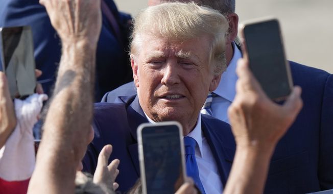 Former President Donald Trump greets supporters as he arrives at New Orleans International Airport in New Orleans, Tuesday, July 25, 2023. (AP Photo/Gerald Herbert)