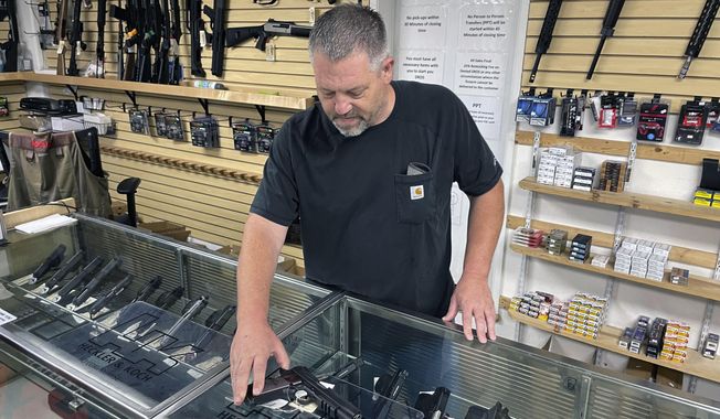 John Parkin, co-owner of Coyote Point Armory displays a handgun at his store in Burlingame, Calif., June 23, 2022. (AP Photo/Haven Daley, File)