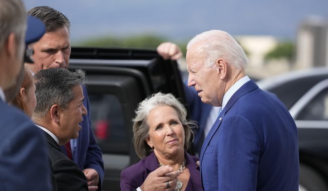 President Joe Biden greets Gov. Lujan Grisham, center, along with Sen. Ben Ray Lujan, D-N.M., and Sen. Martin Heinrich, D-N.M., back left, upon arrival at Kirtland Air Force Base, Tuesday, Aug. 8, 2023, in Albuquerque, N.M. (AP Photo/Alex Brandon)