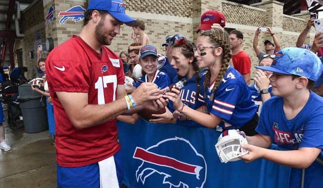 FILE - Buffalo Bills quarterback Josh Allen (17) signs a bottle of barbecue sauce for a fan after practice at the NFL football team&#x27;s training camp in Pittsford, N.Y., Thursday, July 27, 2023. Allen has become accustomed to having his public life picked over and documented with his star status in Buffalo and beyond showing no signs of cresting. (AP Photo/Adrian Kraus, File)