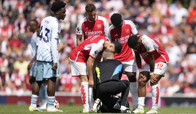 Arsenal&#x27;s Jurrien Timber, right, talks to a team medical staff member during the English Premier League soccer match between Arsenal and Nottingham Forest at Emirates stadium in London, Saturday, Aug. 12, 2023. (AP Photo/Kirsty Wigglesworth)