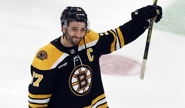 FILE - Boston Bruins&#x27; Patrice Bergeron raises his stick to the fans after losing to the Florida Panthers in overtime during Game 7 of an NHL hockey Stanley Cup first-round playoff series, Sunday, April 30, 2023, in Boston. Bruins forward Patrice Bergeron has retired. The five-time Selke Trophy winner announced Tuesday, July 25, 2023, that he will not return for a 20th season with the only team he has ever played for. The Bruins captain said he is leaving with no regrets.(AP Photo/Michael Dwyer, File)