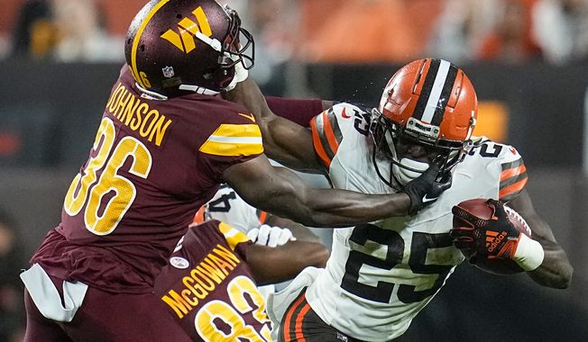 Cleveland Browns running back Demetric Felton Jr. is tackled by Washington Commanders cornerback Danny Johnson during the first half of a preseason NFL football game on Friday, Aug. 11, 2023, in Cleveland. (AP Photo/Sue Ogrocki)