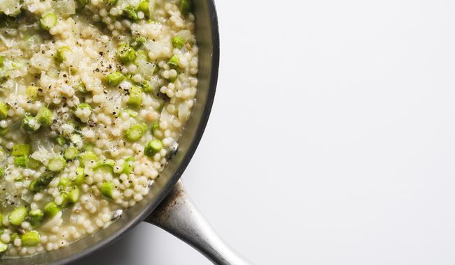 This image released by Milk Street shows a recipe for couscous risotto with asparagus. (Milk Street via AP)