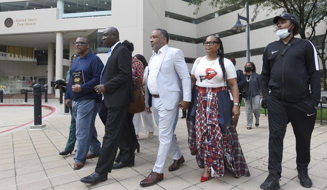 Attorney Ben Crump, second from left, walks with Ron Lacks, left, Alfred Lacks Carter, third from left, both grandsons of Henrietta Lacks, and other descendants of Lacks, outside the federal courthouse in Baltimore, Oct. 4, 2021. The family of Henrietta Lacks is settling a lawsuit against a biotechnology company it accuses of improperly profiting from her cells. Their federal lawsuit in Baltimore claimed Thermo Fisher Scientific has made billions from tissue taken without the Black woman’s consent from her cervical cancer tumor. (AP Photo/Steve Ruark, file)