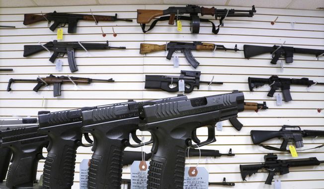 Semi-automatic guns are displayed for sale at Capitol City Arms Supply, Jan. 16, 2013, in Springfield, Ill. (AP Photo/Seth Perlman, File)