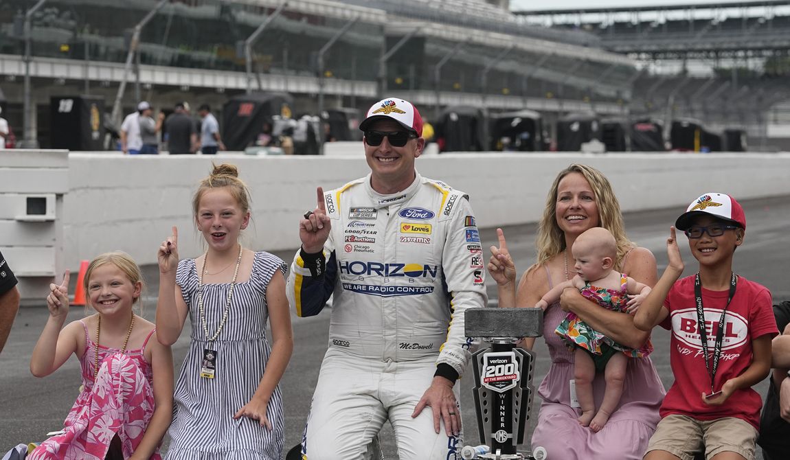 Michael McDowell celebrates with his family after winning the NASCAR Cup Series auto race at Indianapolis Motor Speedway, Sunday, Aug. 13, 2023, in Indianapolis. (AP Photo/Darron Cummings)