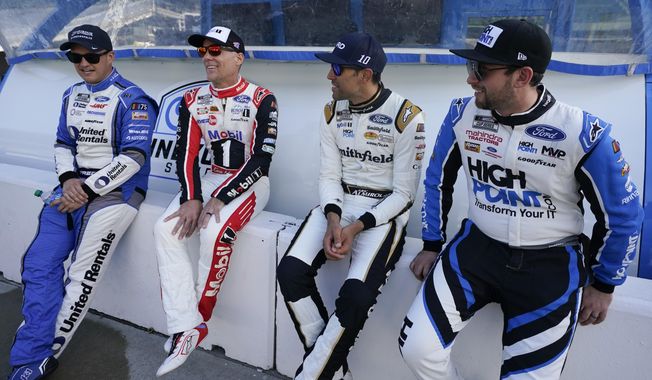 Ryan Preece, Kevin Harvick, Aric Almirola and Chase Briscoe, from left, talk before a practice session for the NASCAR Cup Series auto race at Indianapolis Motor Speedway, Saturday, Aug. 12, 2023, in Indianapolis. (AP Photo/Darron Cummings)
