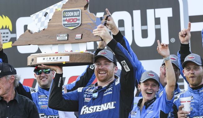 Chris Buescher raises the Cook Out 400 Trophy in Victory Lane after winning a NASCAR Cup Series auto race, Sunday, July 30, 2023, in Richmond, Va. (AP Photo/Skip Rowland)