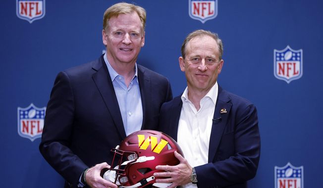 NFL Commissioner Roger Goodell presents new Washington Commanders owner Josh Harris with a team helmet after a special meeting to vote on approval of the sale of the team, Thursday, July 20, 2023, in Bloomington Minn. (AP Photo/Bruce Kluckhohn)