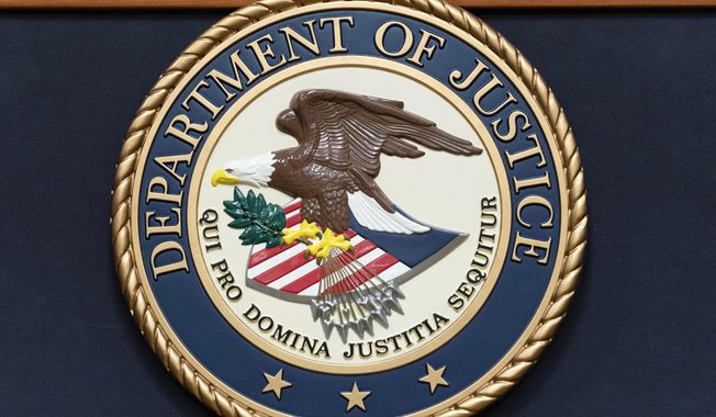 The Department of Justice seal is seen before a news conference to announce an international ransomware enforcement action at the Department of Justice in Washington, Jan. 26, 2023. On Friday, July 21, The Associated Press reported on stories circulating online incorrectly claiming the U.S. Department of Justice said international child sex trafficking is not an area of concern. (AP Photo/Jose Luis Magana, File)