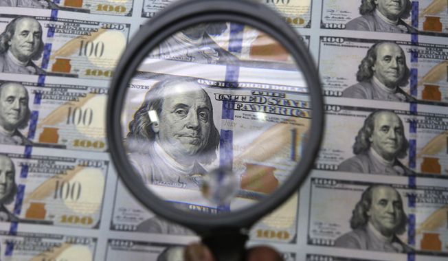 A sheet of uncut $100 bills is inspected during the printing process at the Bureau of Engraving and Printing Western Currency Facility in Fort Worth, Texas, on Sept. 24, 2013. More than $200 billion may have been stolen from two large pandemic-relief initiatives, according to new estimates from a federal watchdog investigating federally funded programs designed to help small businesses survive the worst public health crisis in more than a hundred years. (AP Photo/LM Otero, File)