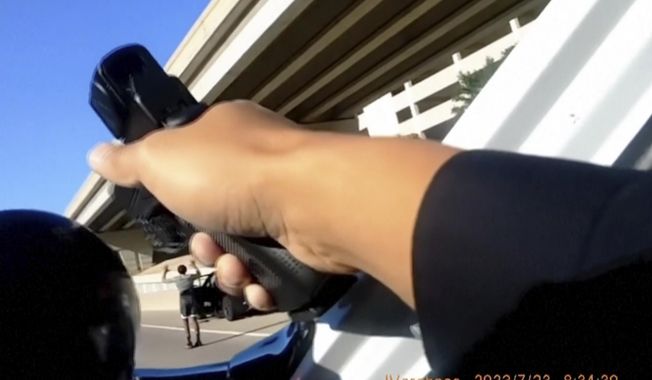 In this image taken from police body camera video released by the Frisco, Texas, Police Department, a police officer displays his weapon during after stopping a vehicle on July 23, 2023. Demetria Heard, a Black woman from Arkansas who was held at gunpoint along with three family members when Texas police wrongly suspected their car was stolen said Thursday, Aug. 3, 2023, that she decided to speak out after seeing video from a passerby and realizing two officers had aimed firearms at her 13-year-old son while his hands were up. Police in the Dallas suburb have apologized and acknowledged that during the traffic stop, an officer misread the Dodge Charger&#x27;s license plate as the family left a hotel to go to a basketball tournament. (Frisco Police Department via AP)