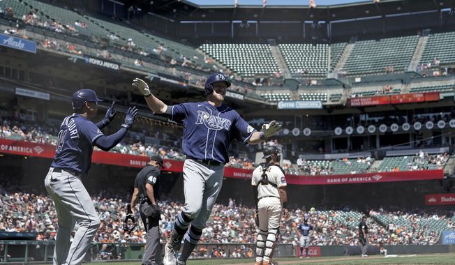 Tampa Bay Rays&#x27; Luke Raley, center, celebrates with Christian Bethancourt, left, after hitting an inside-the-park home run during the sixth inning of a baseball game against the San Francisco Giants, Wednesday, Aug. 16, 2023, in San Francisco. (AP Photo/Godofredo A. Vásquez)