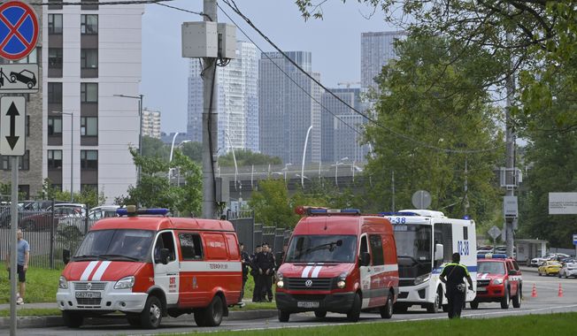 Police and emergency vehicles parked at the side of the wreckage of the drone fell near the Karamyshevskaya embankment to the after a reported drone attack in Moscow, Russia, on Friday, Aug. 11, 2023. The Mayor of Moscow, Sergei Sobyanin said a drone fell in western Moscow after it was shot down by air defense systems. Sobyanin said no-one was hurt when the drone fell near Karamyshevskaya embankment and that no serious damage was caused. Russian social media channels shared videos of what they said was a drone flying low above Moscow and of smoke rising above the Moscow river. (AP Photo)