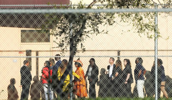 Nine members of Congress wait to enter Marjory Stoneman Douglas High School, Friday, Aug. 4, 2023, in Parkland, Fla. The group will tour the blood-stained and bullet-pocked halls, shortly before ballistics technicians reenact the massacre that left 14 students and three staff members dead in 2018. The reenactment is part of a lawsuit filed by the victims&#x27; families against former Deputy Scot Peterson and the Broward Sheriff&#x27;s Office. (AP Photo/Marta Lavandier)