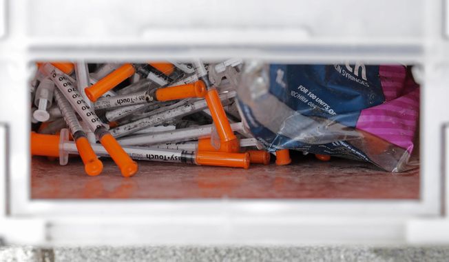 A box of needles collected at a homeless encampment at Ballard Commons Park is shown on May 4, 2020, in Seattle. Seattle Mayor Bruce Harrell is asking members of the city council who recently voted against adopting the state&#x27;s controlled substance law to consider an amended plan. Harrell on Monday, July 31, 2023, offered a proposal that would align the city&#x27;s code with new state law, making possession and public use of drugs such as fentanyl a gross misdemeanor. (AP Photo/Ted S. Warren, File)