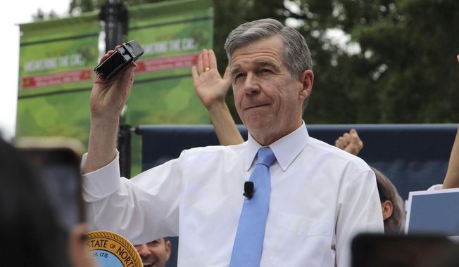 North Carolina Democratic Gov. Roy Cooper affixes his veto stamp to a bill banning nearly all abortions after 12 weeks of pregnancy at a public rally, May 13, 2023, in Raleigh, N.C. Transgender rights take center stage in North Carolina again Wednesday, Aug. 16, as GOP supermajorities in the General Assembly attempt to override the governor&#x27;s vetoes of legislation banning gender-affirming health care for minors and limiting transgender participation in school sports. (AP Photo/Hannah Schoenbaum, File)