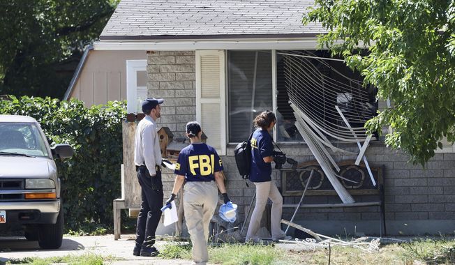 FILE - Law enforcement investigate the scene of a shooting involving the FBI, Wednesday, Aug. 9, 2023, in Provo, Utah. Craig Robertson, the 75-year-old man shot by officers trying to arrest him for social media threats he made against officials including President Joe Biden had a history of &quot;exercising his 2nd Amendment rights, albeit a little recklessly,” according to Utah police records. (Laura Seitz/The Deseret News via AP, File)