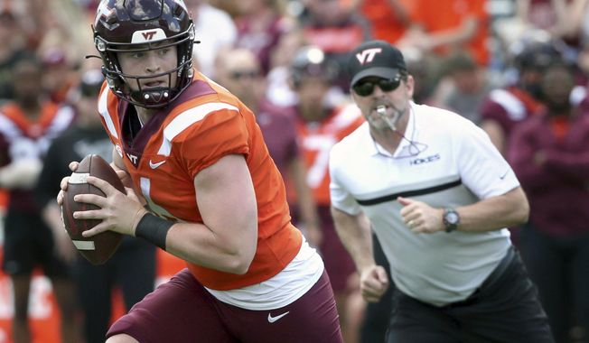 Virginia Tech quarterback Grant Wells (6) rolls out while observed by head coach Brent Pry during the team&#x27;s spring NCAA college football game in Blacksburg, Va., Saturday, April 15, 2023. Virginia Tech opens their season at home against Old Dominion on Sept. 2. (Matt Gentry/The Roanoke Times via AP, File)