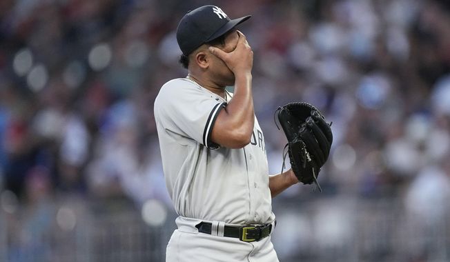 New York Yankees starting pitcher Randy Vasquez wipes his face as he waits for manager Aaron Boone to remove him during the fourth inning of the team&#x27;s baseball game against the Atlanta Braves, Wednesday, Aug. 16, 2023, in Atlanta. (AP Photo/John Bazemore)